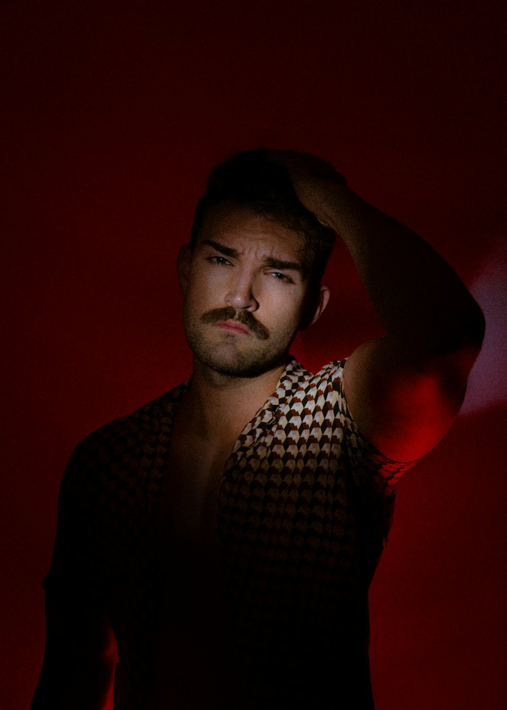 a man with a goatee standing in a dark room