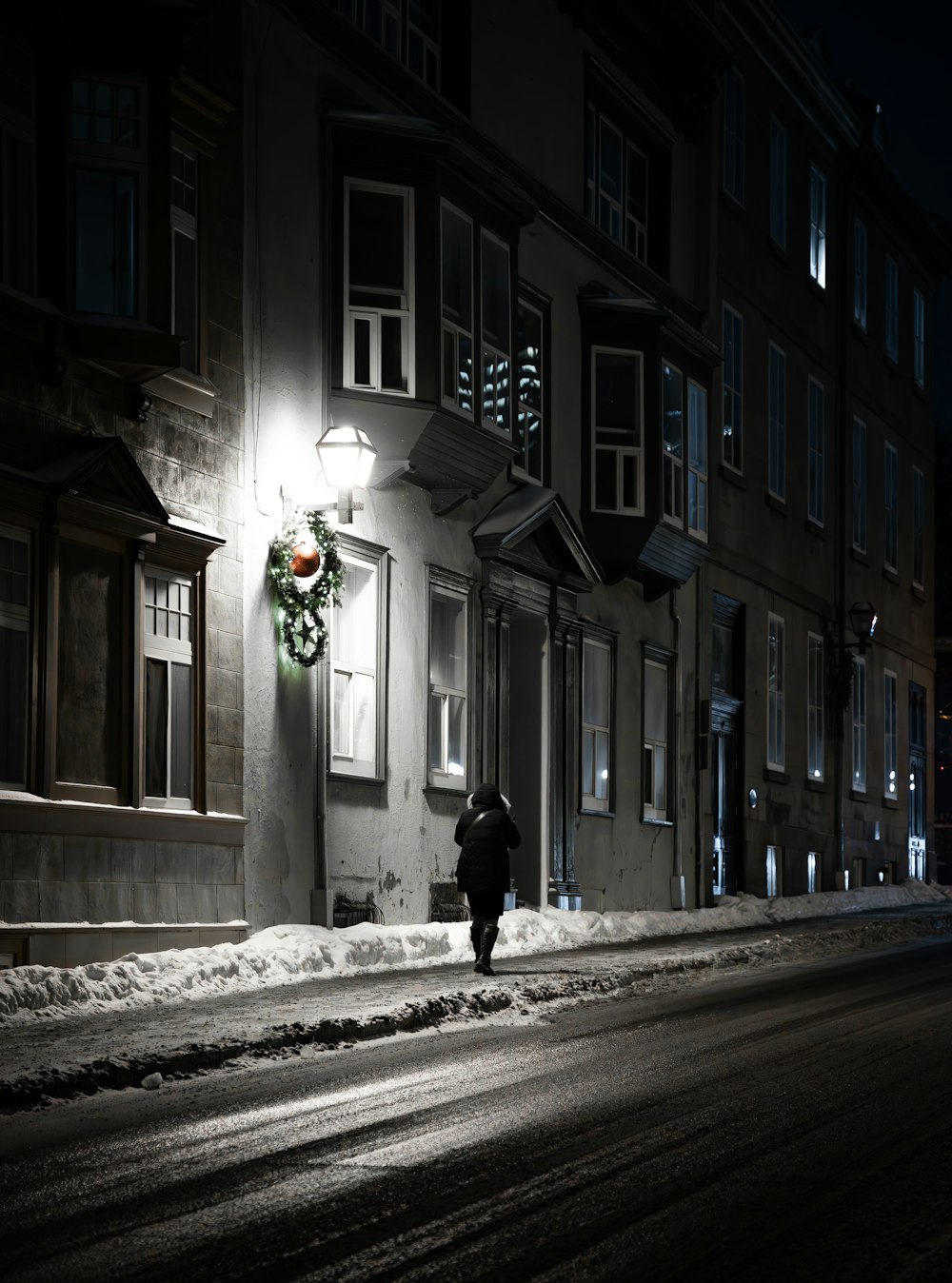 a person walking down a snowy street at night