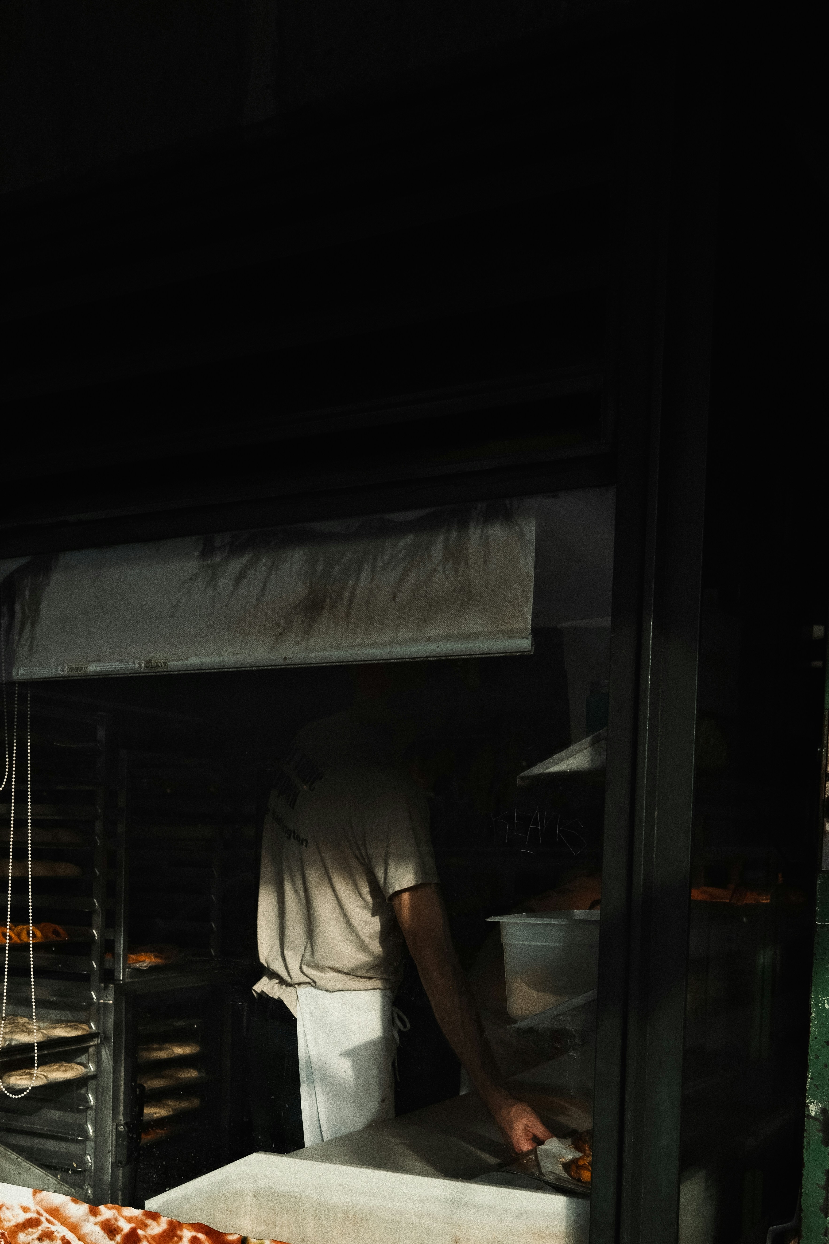 a man standing in front of a pizza oven