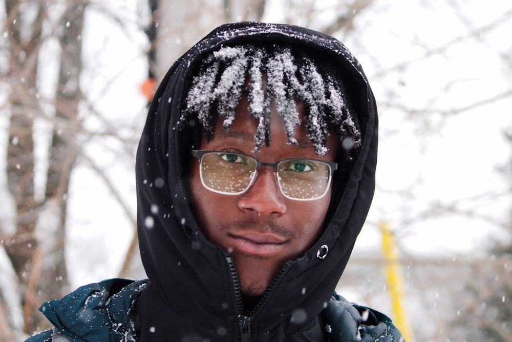 a young man wearing glasses in the snow