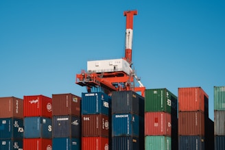 a crane is on top of a large stack of containers