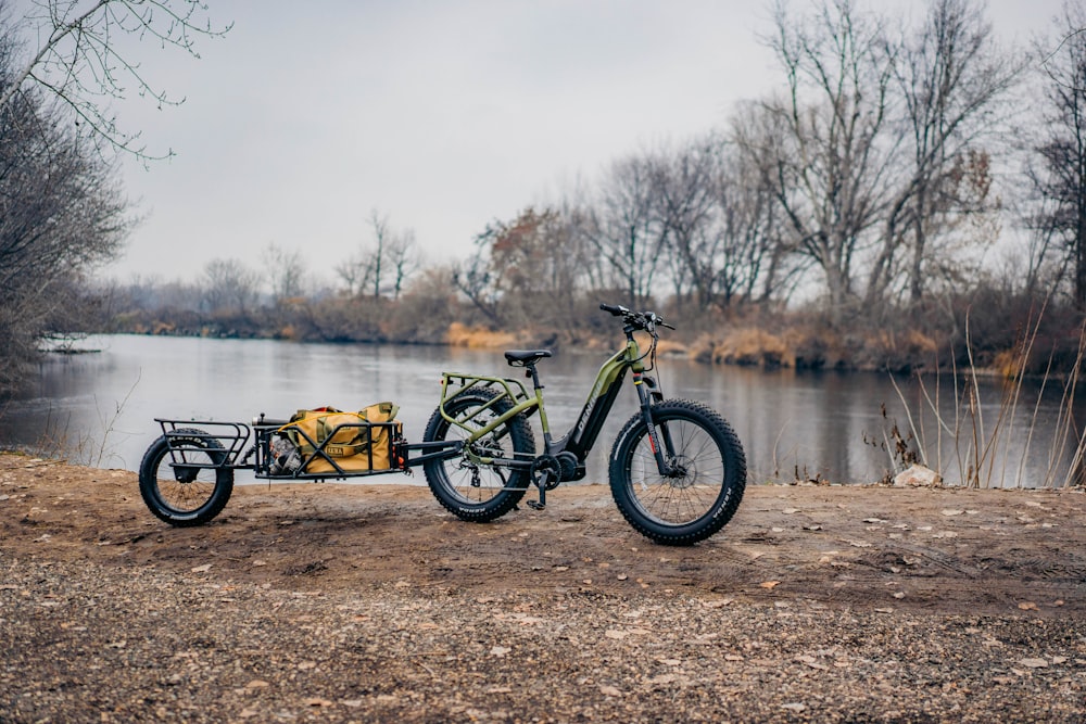 a bike with a trailer parked next to a body of water