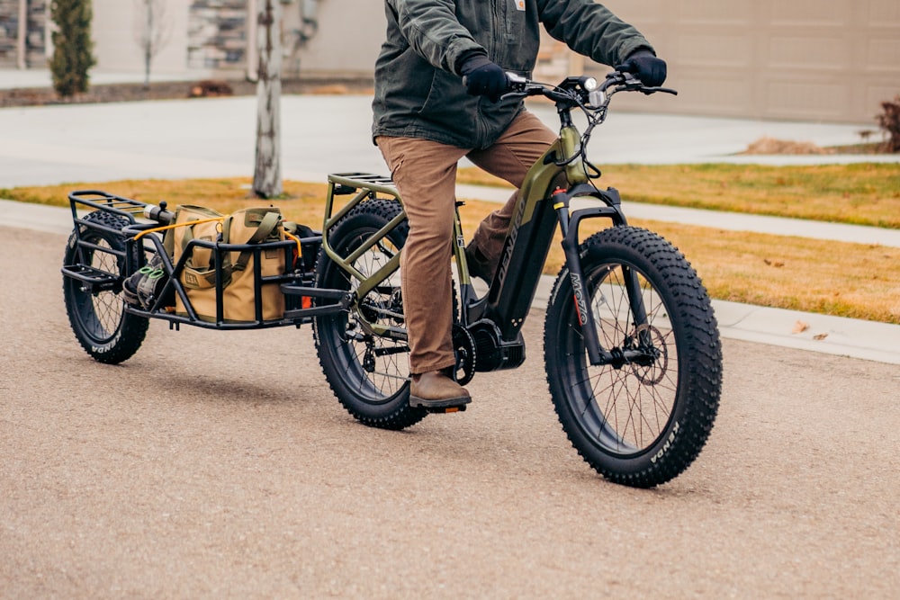 a man riding a bike with a trailer attached to it