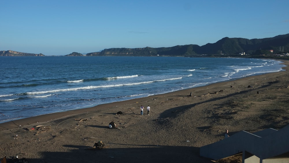 a beach with a few people walking on it