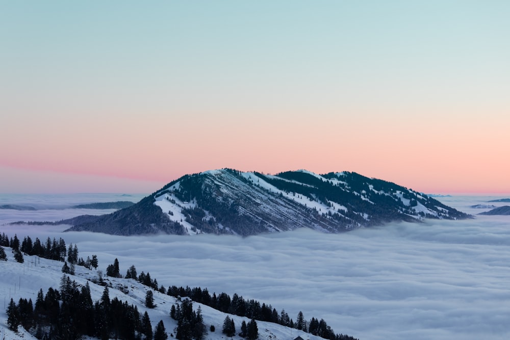 una montaña cubierta de nieve y rodeada de nubes