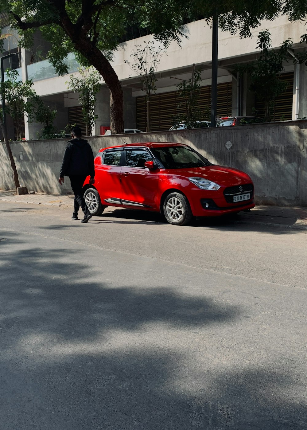 un'auto rossa parcheggiata sul ciglio della strada