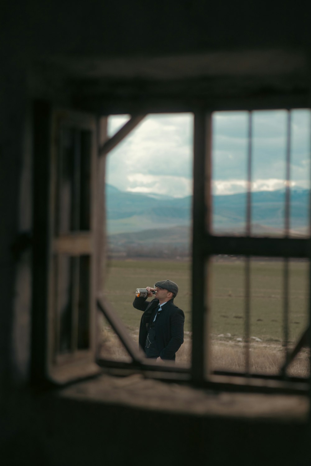 Un homme prend une photo à travers une fenêtre