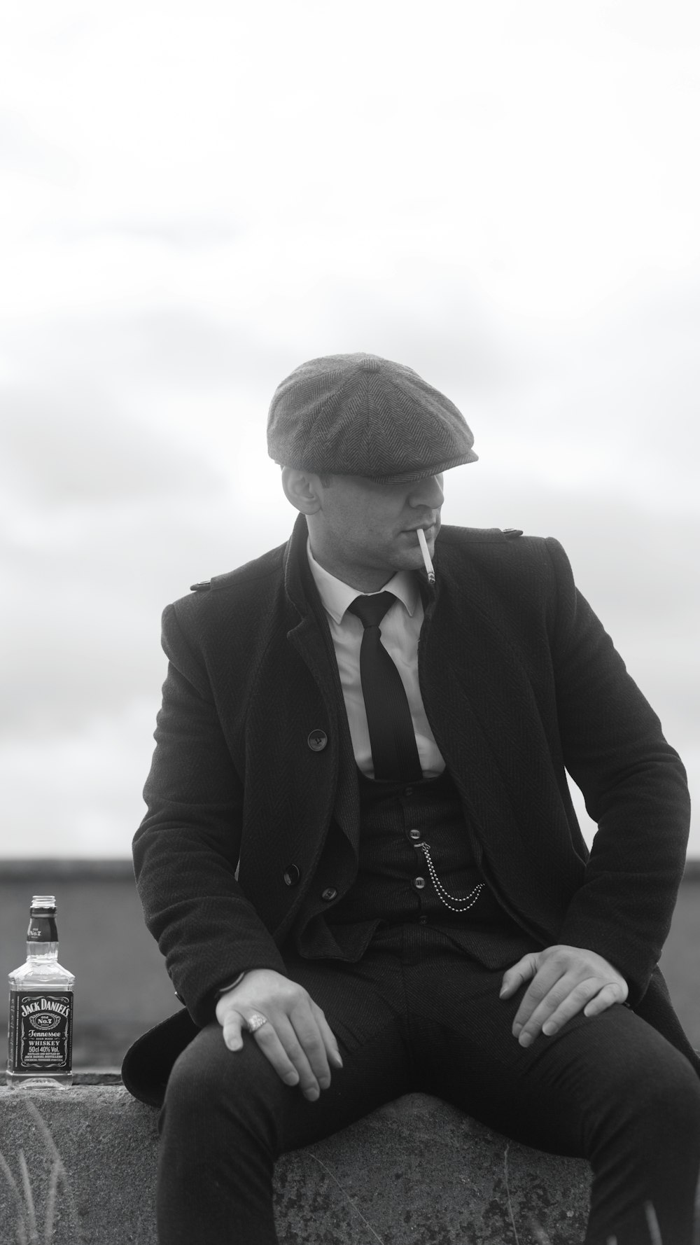 a man in a suit and tie sitting on a wall