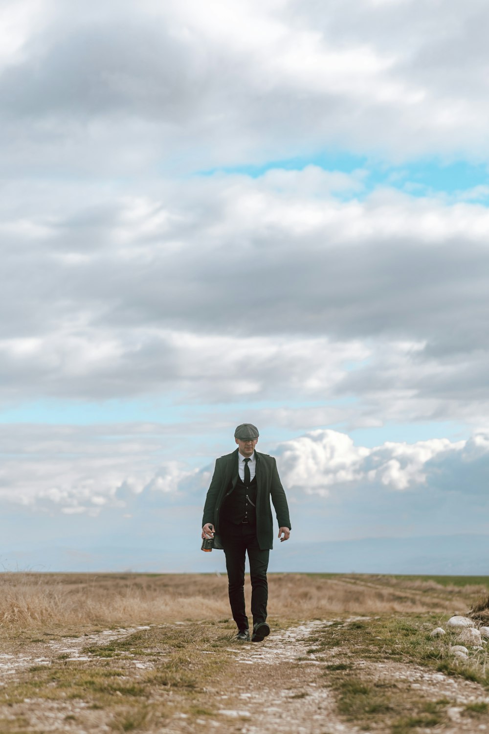 a man in a suit and tie walking across a field