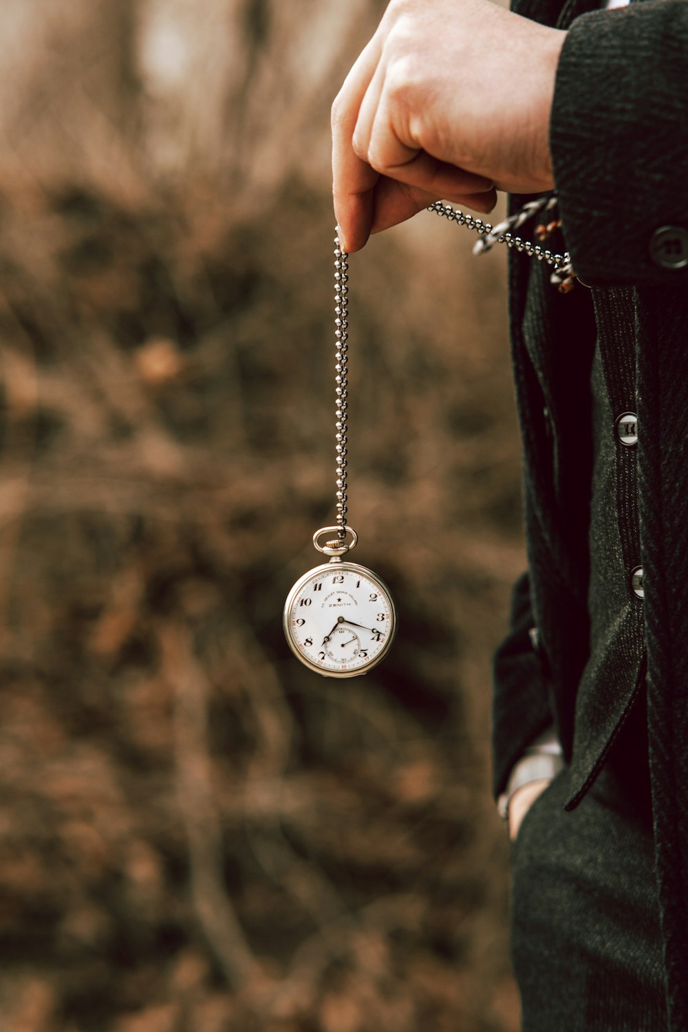 une personne tenant une montre de poche à la main