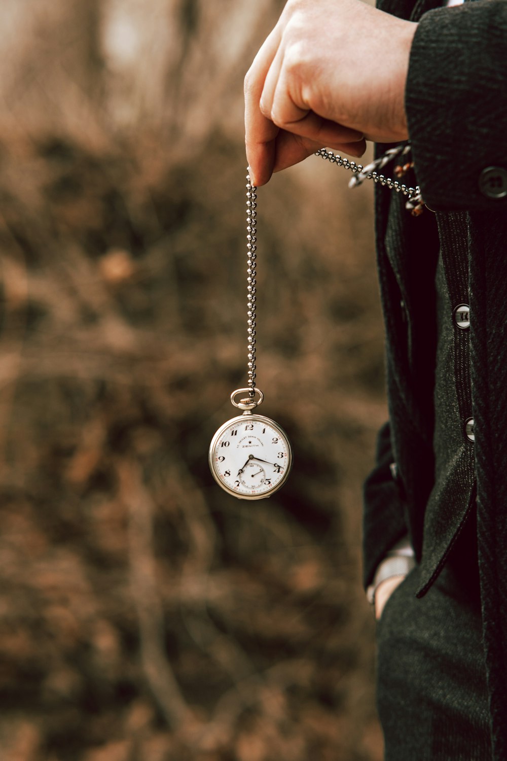 a person holding a pocket watch in their hand