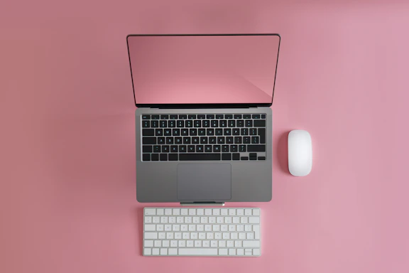 a laptop computer sitting on top of a white keyboard