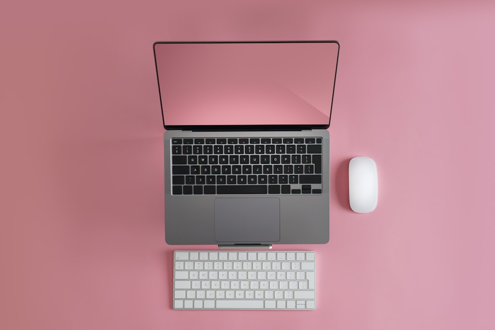 a laptop computer sitting on top of a white keyboard