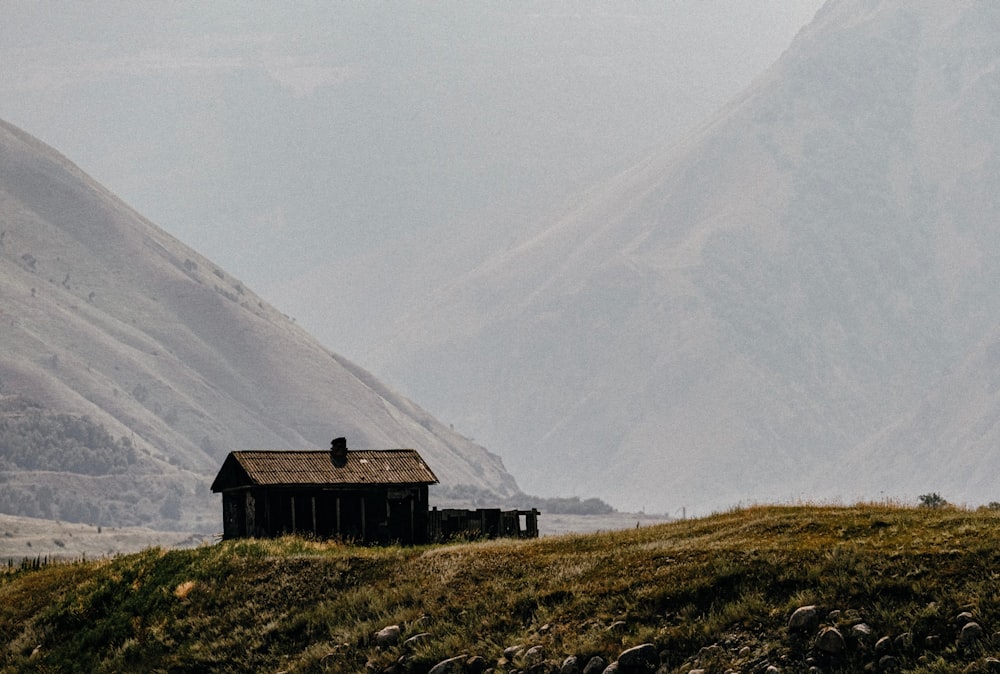 a house on a hill with mountains in the background