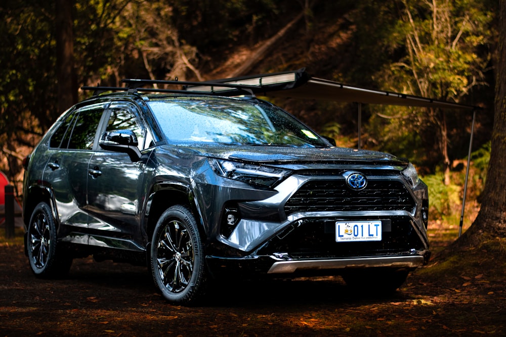 a black toyota rav parked in the woods