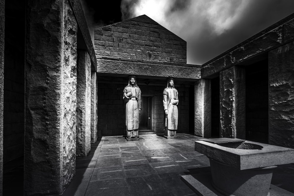 a black and white photo of two statues
