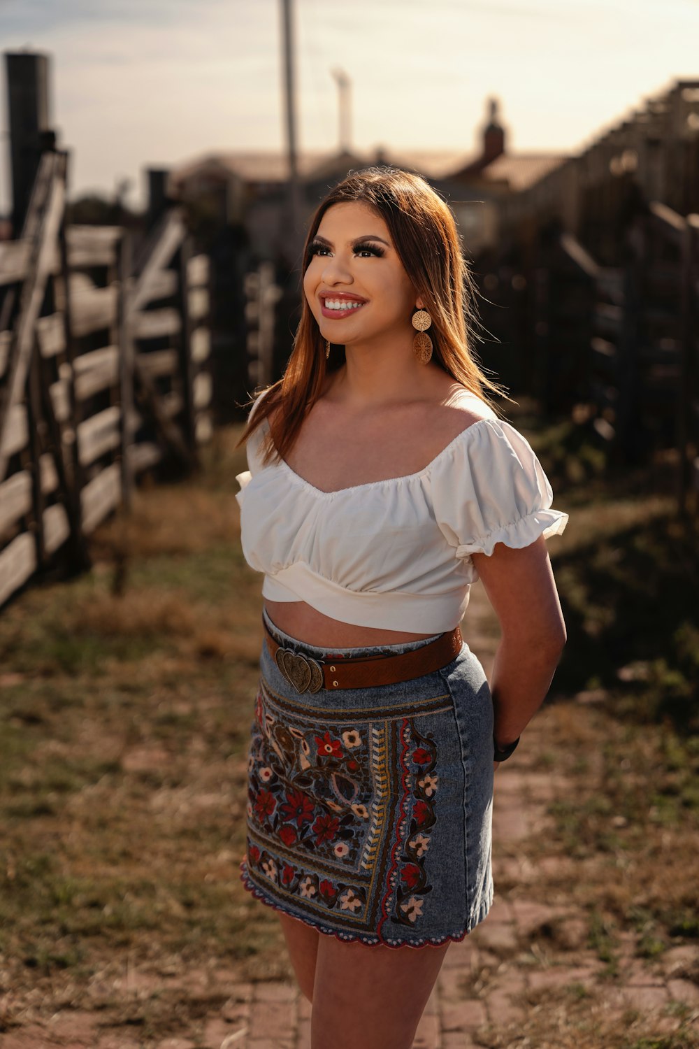 a woman in a white top and a denim skirt