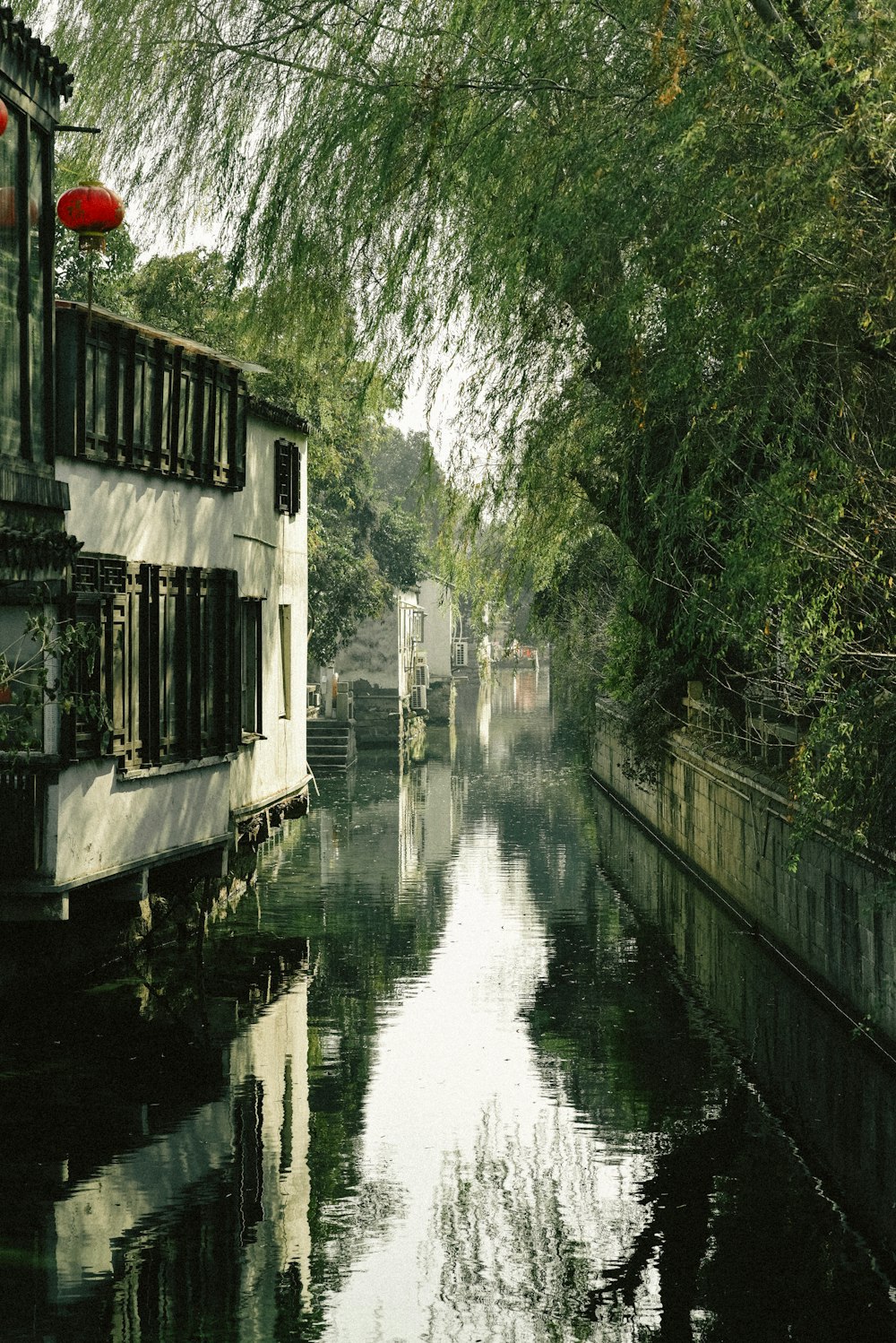 a narrow canal with a house on the other side