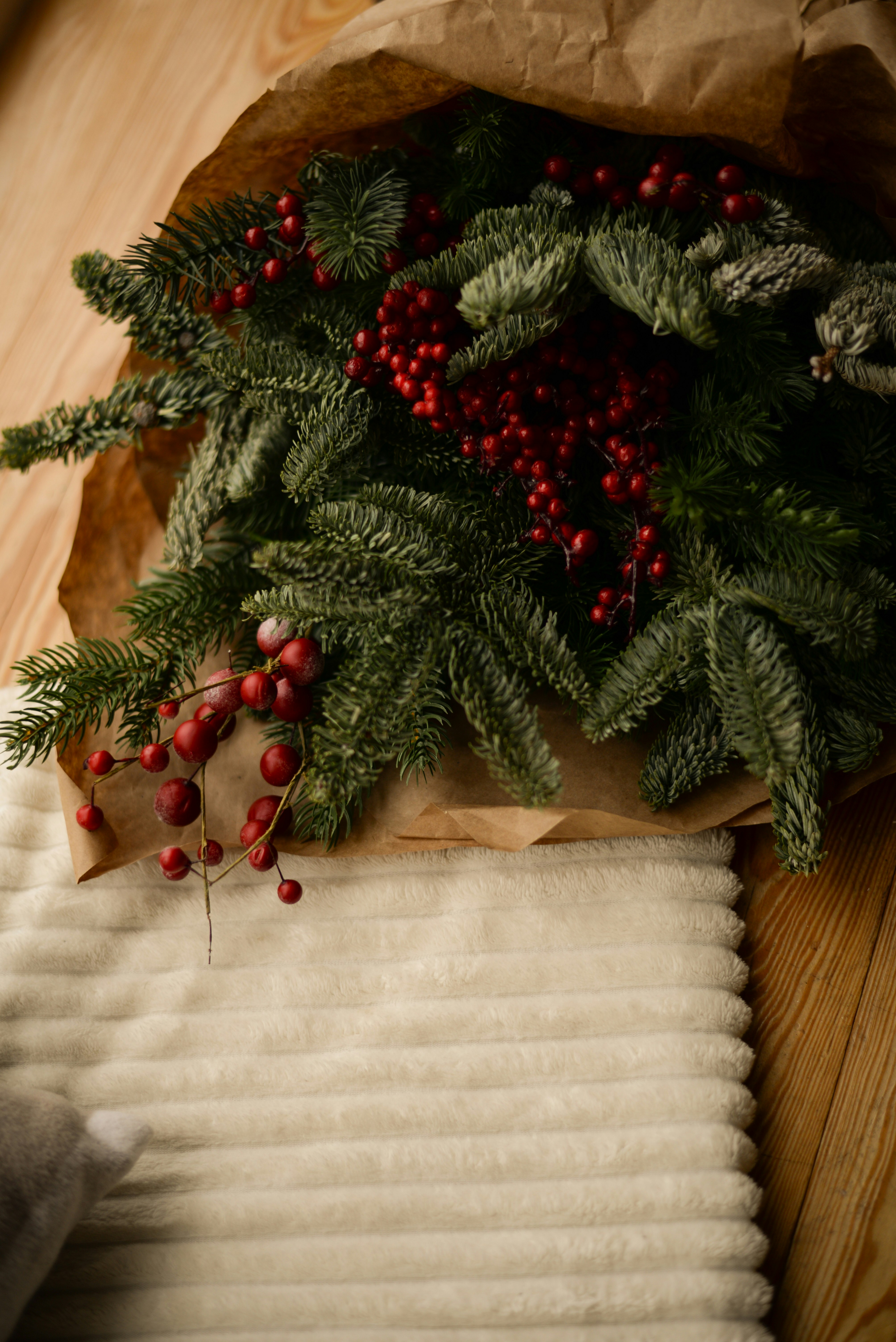 a paper bag filled with holly and red berries