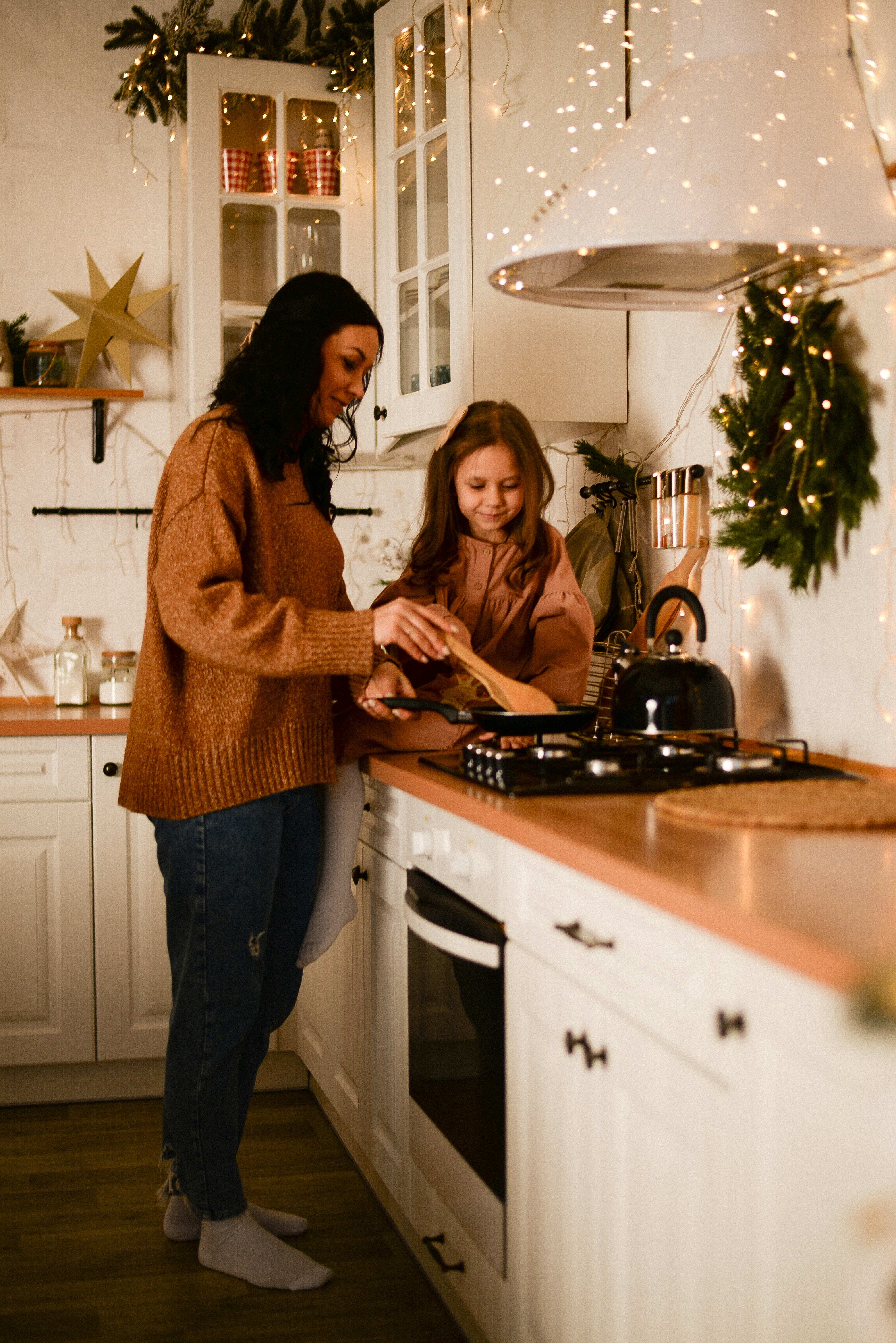 a couple of women standing in a kitchen preparing food