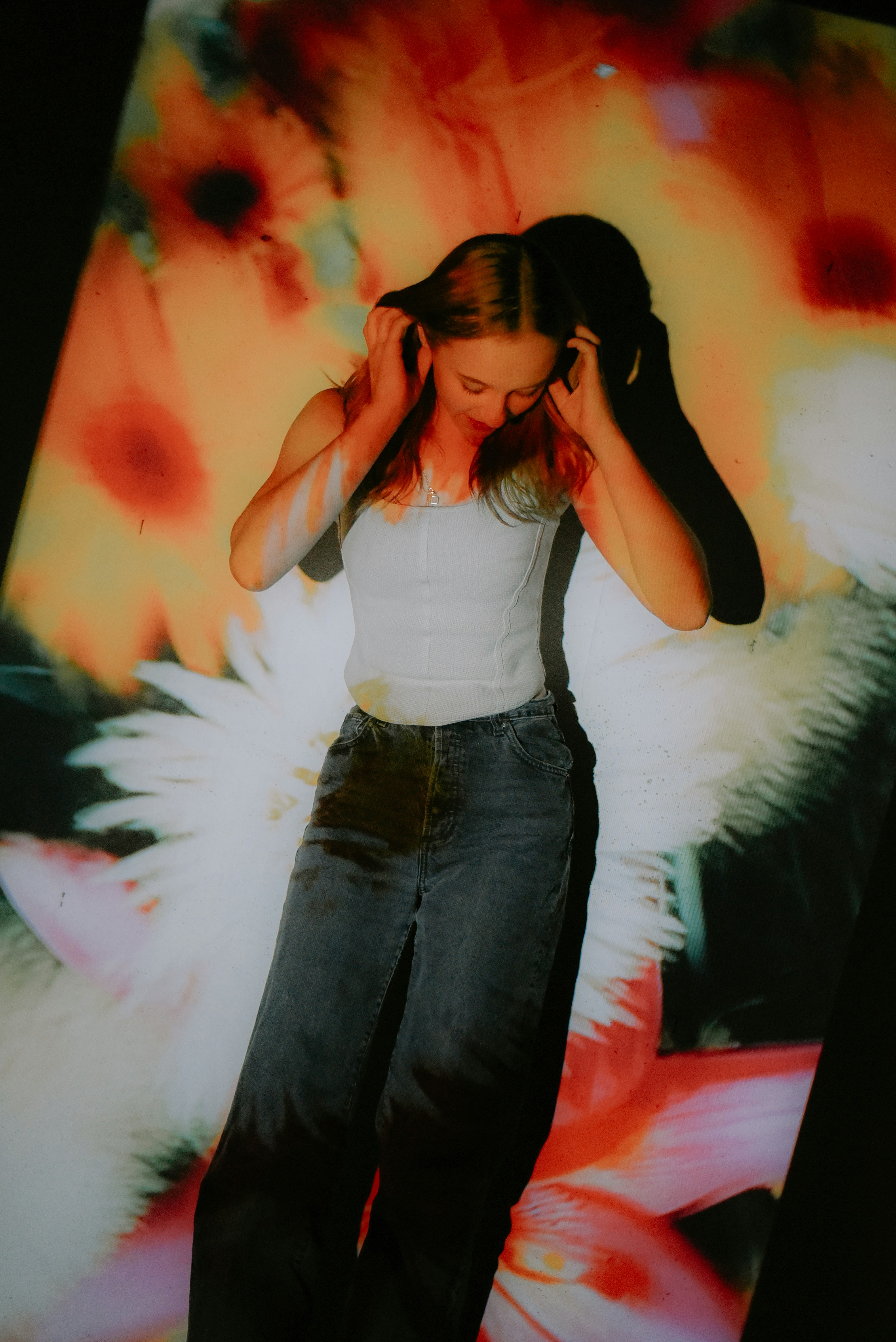 a woman standing in front of a picture of flowers