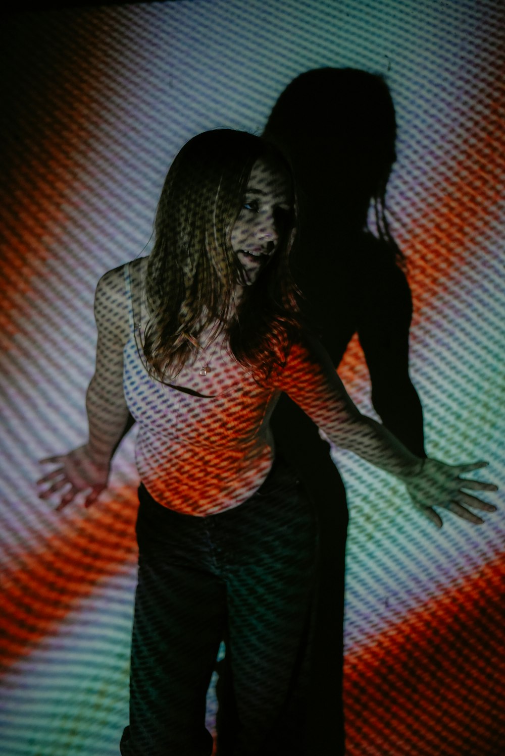 a woman standing in front of a projection screen