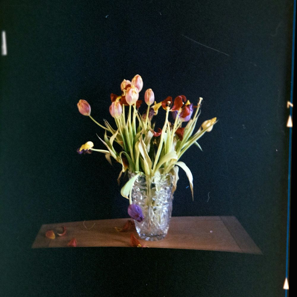 a vase filled with lots of flowers on top of a table