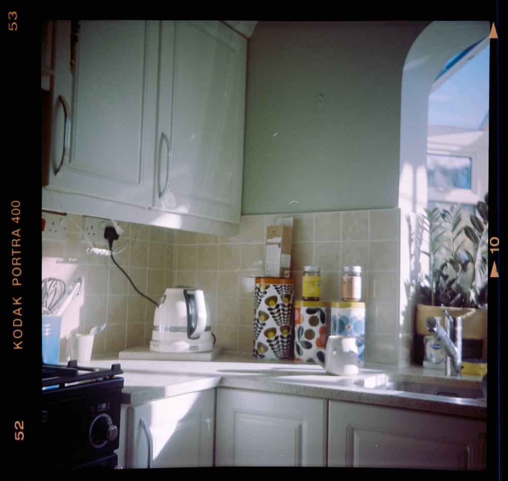 a kitchen with white cabinets and a black stove top oven