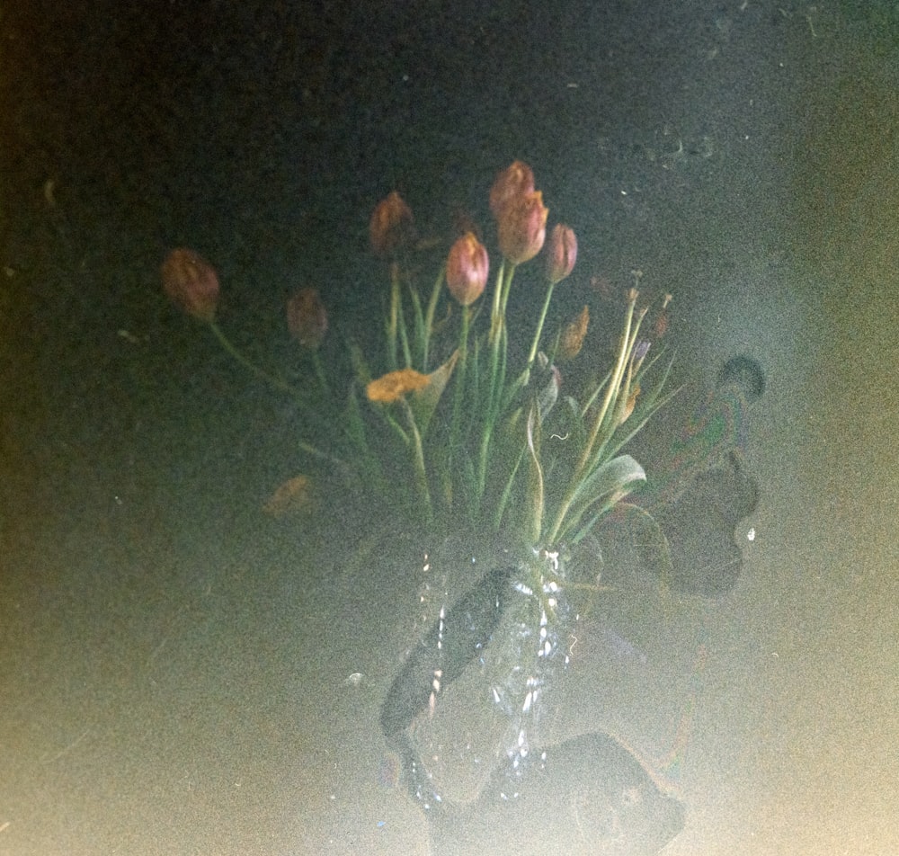 um vaso cheio de muitas flores em cima de uma mesa