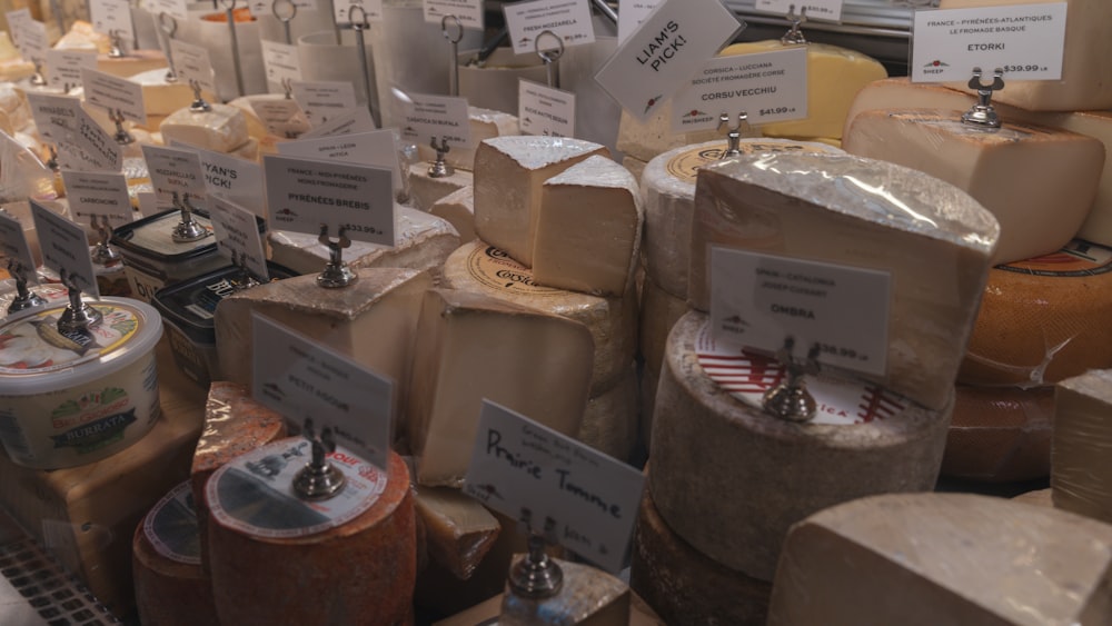 many different types of cheese on display in a store