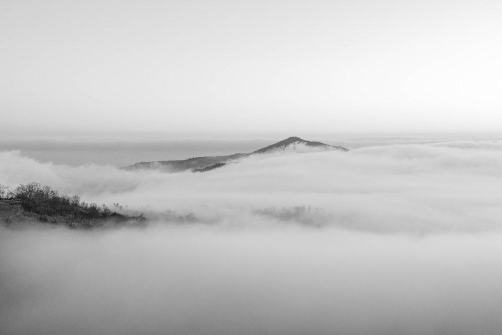 a black and white photo of a foggy mountain