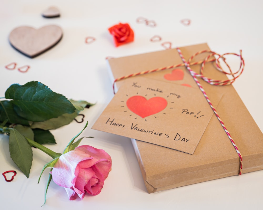 Um cartão de Dia dos Namorados e uma rosa sobre uma mesa