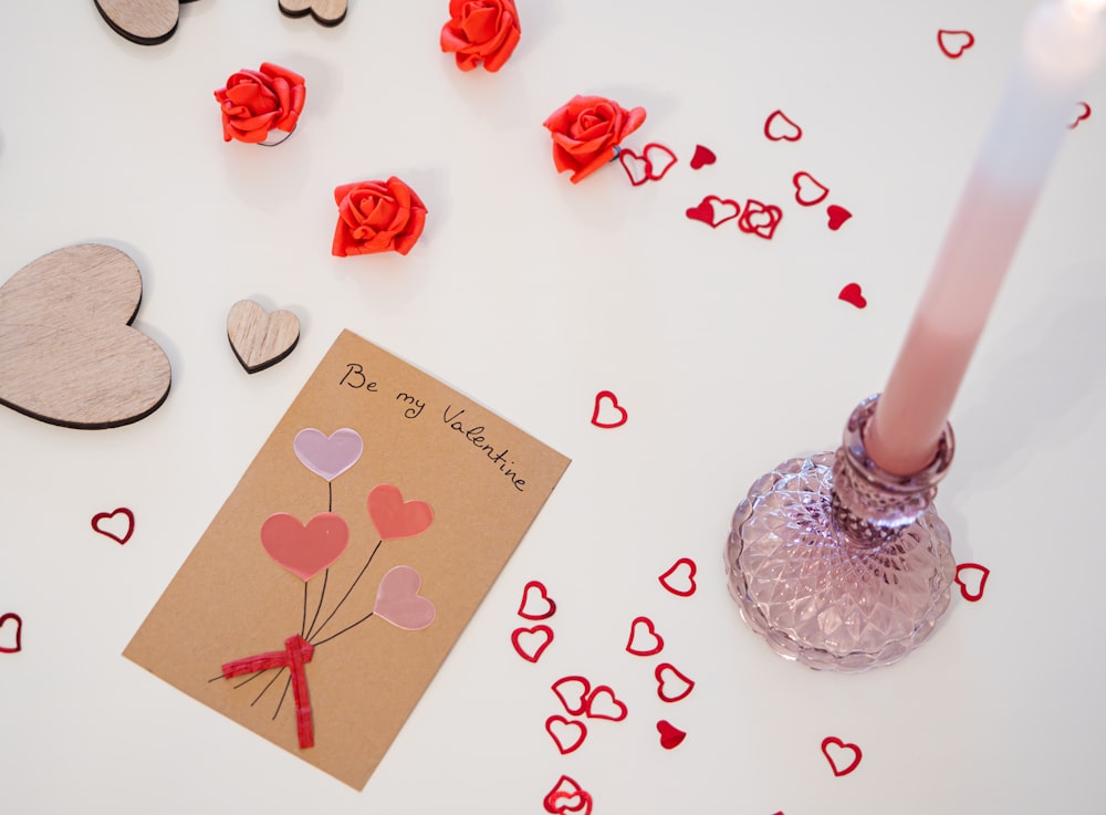 a valentine's day card and a candle on a table