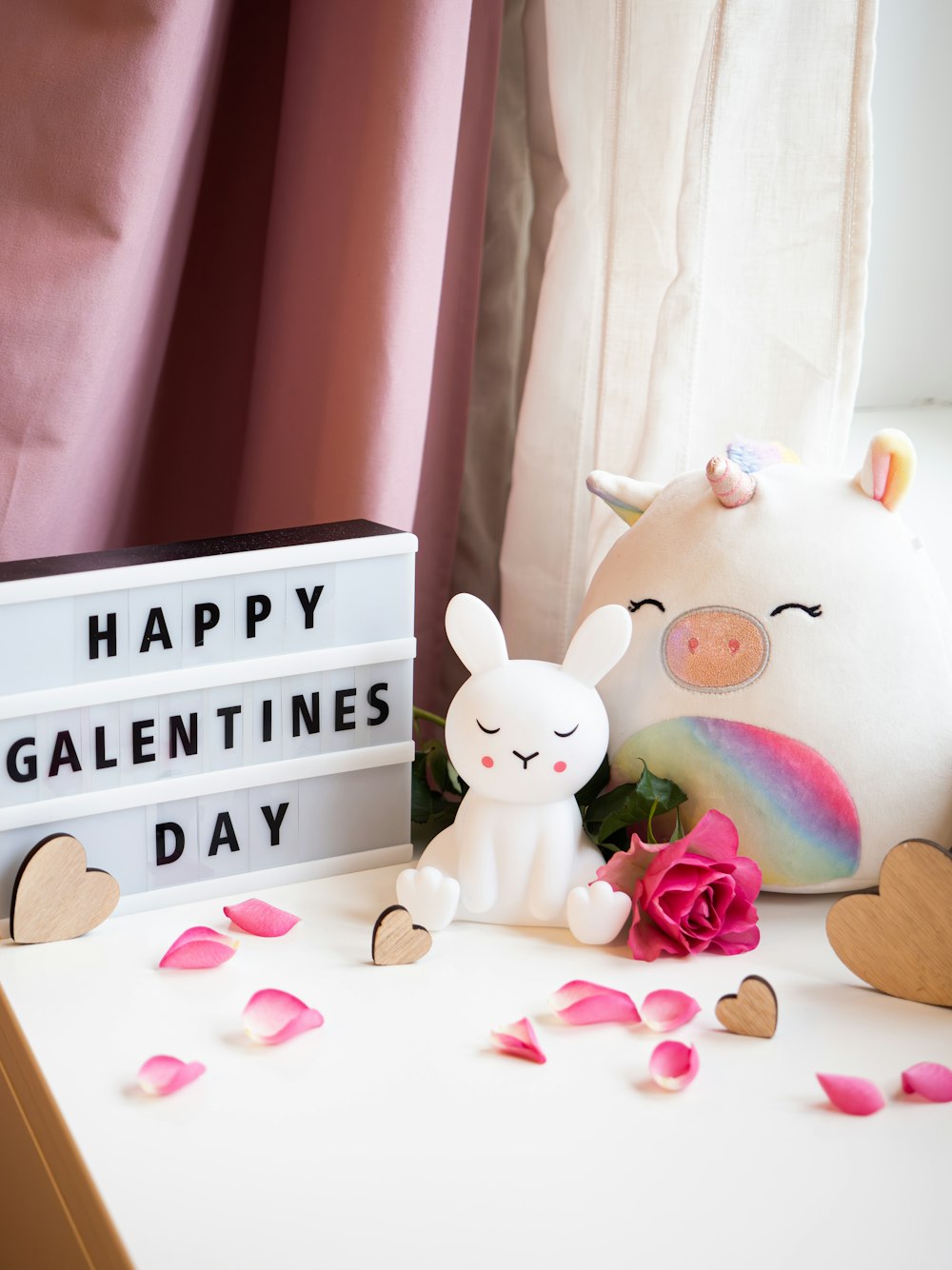 a white stuffed animal next to a sign that says happy valentine's day