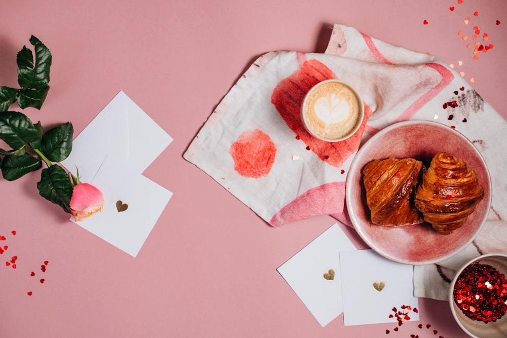 a pink table topped with a plate of food and a cup of coffee