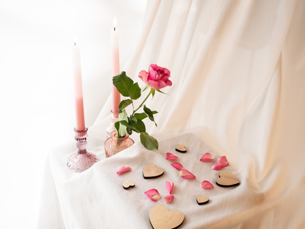 a table topped with a vase filled with pink flowers