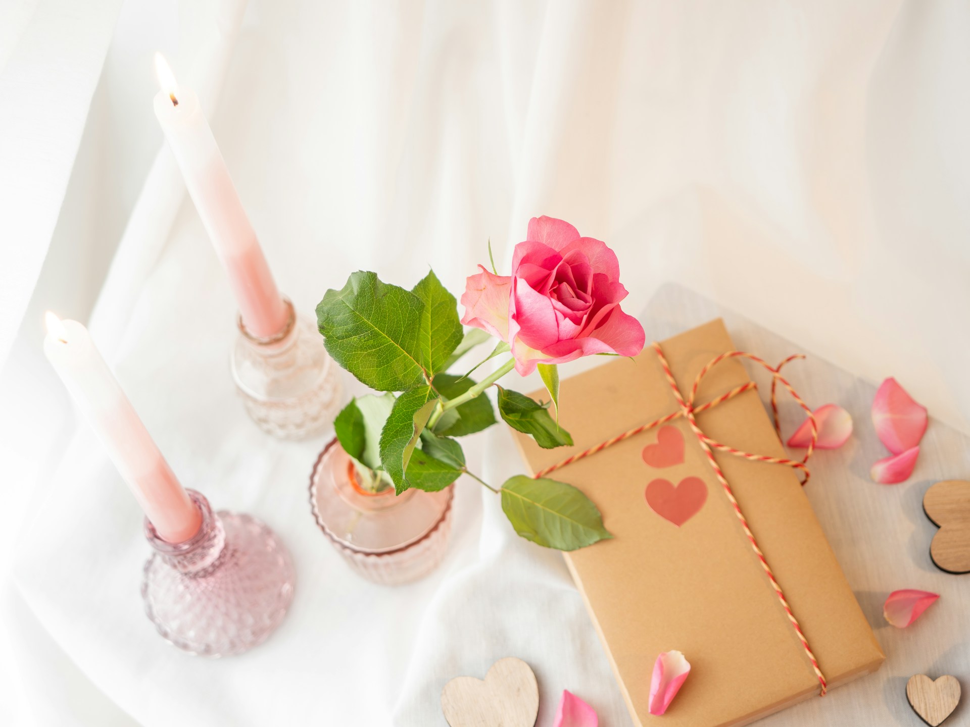 a gift box with a rose and two candles