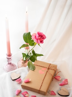 a gift box with a heart cut out of it next to a candle and a