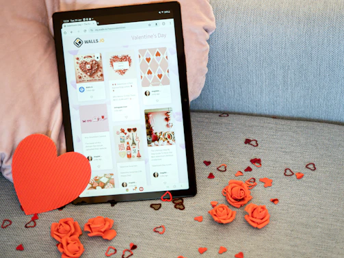 a tablet sitting on a couch next to a red heart