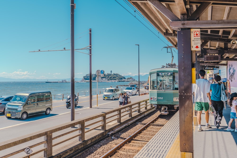 a group of people waiting for a train at a train station