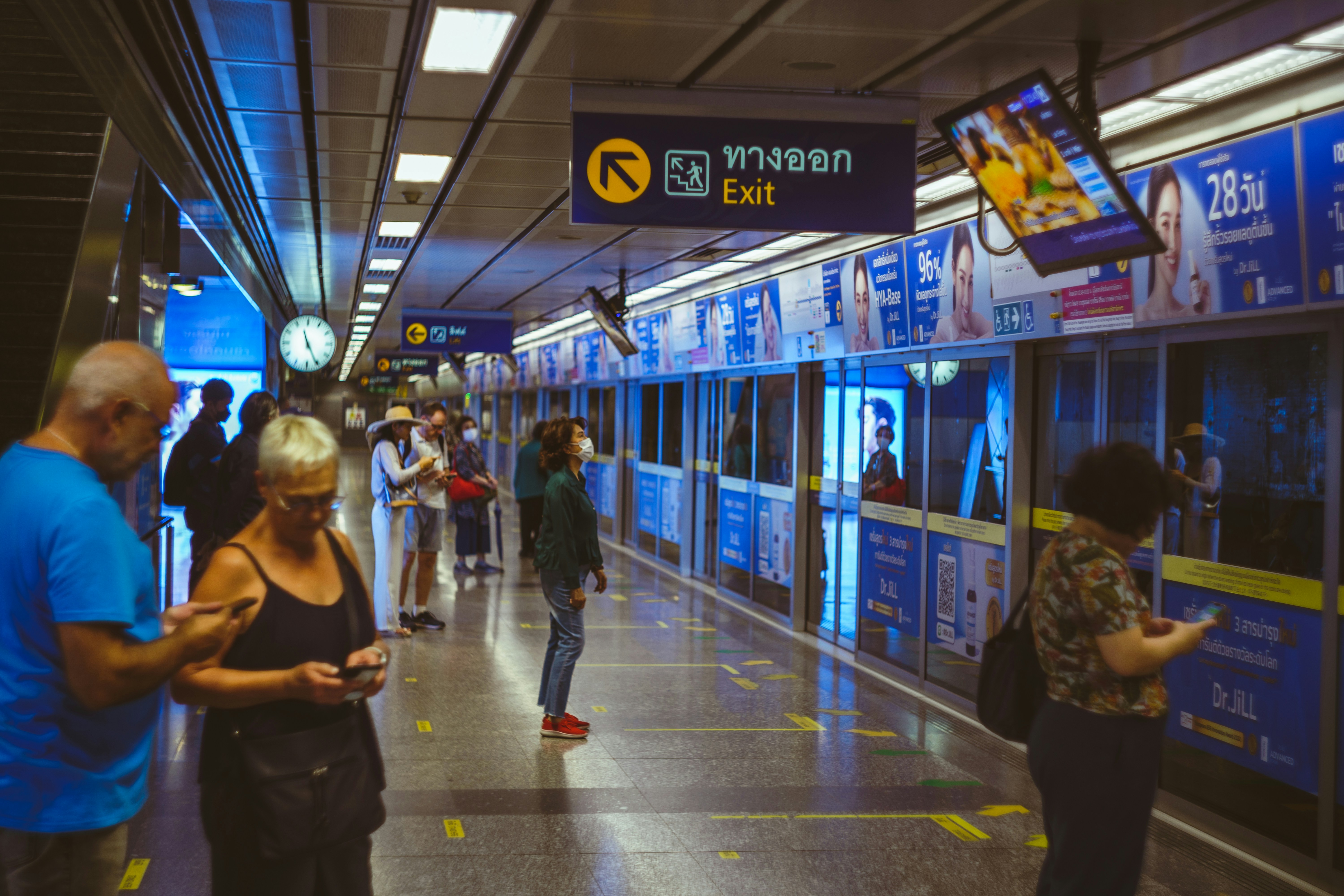 a group of people standing around a train station