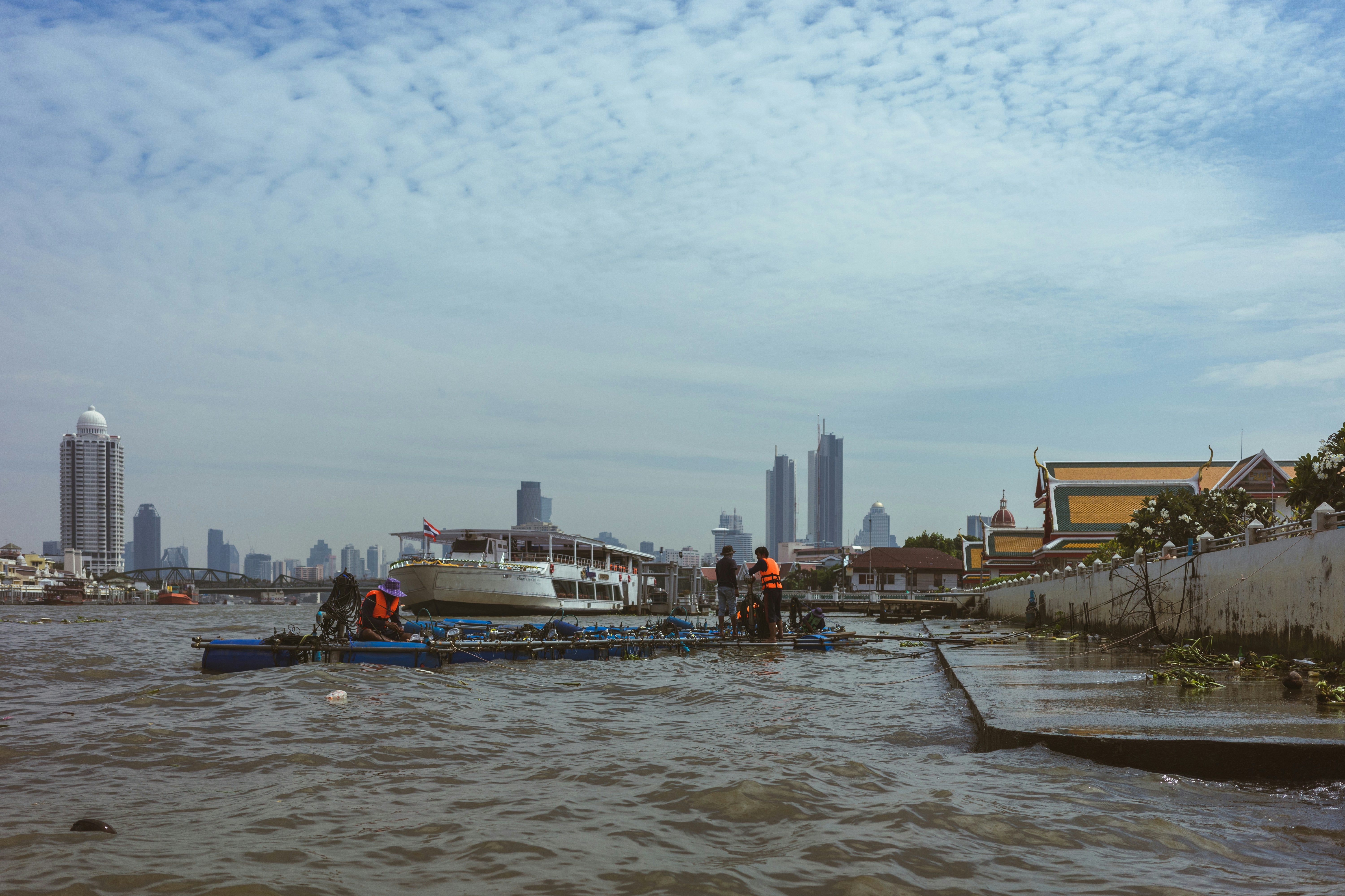 a group of people standing on top of a boat in the water