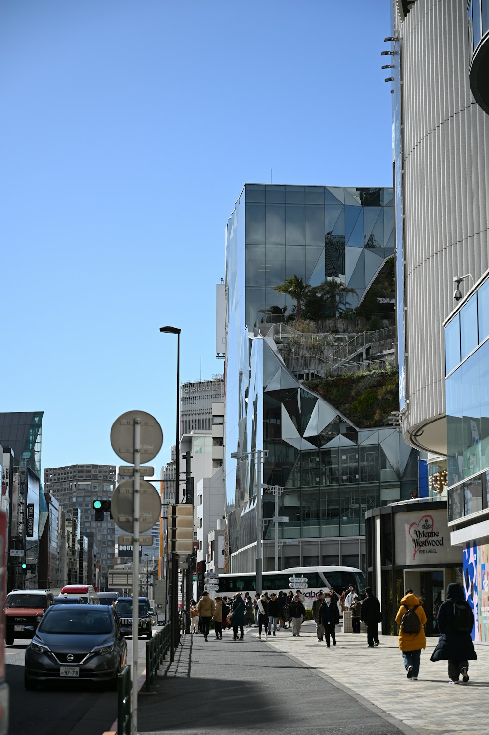 a group of people walking down a street next to tall buildings