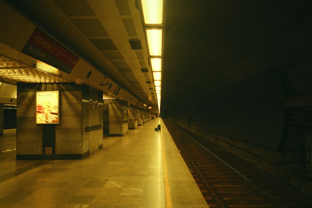 a train station with a person walking on the platform