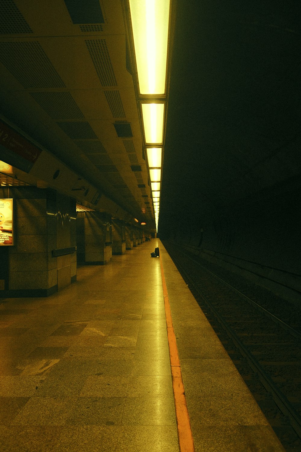 a train station with a person sitting on the platform