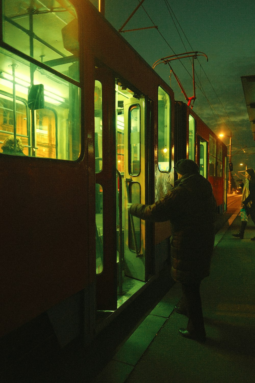 a person getting on a train at night