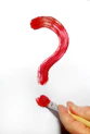 a hand holding a paintbrush and a red question mark