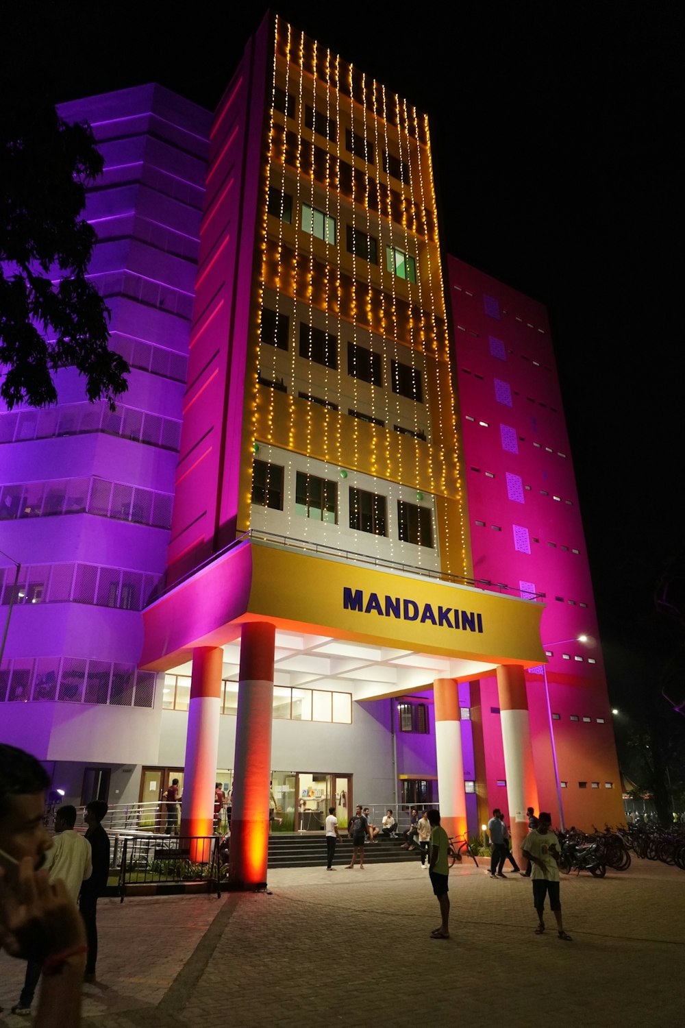 um prédio alto com uma placa iluminada ao lado