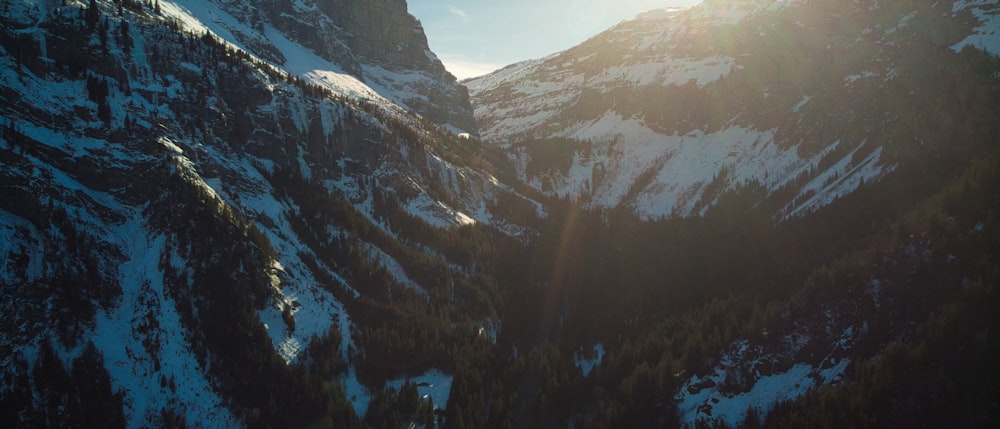 the sun shines brightly on a snowy mountain