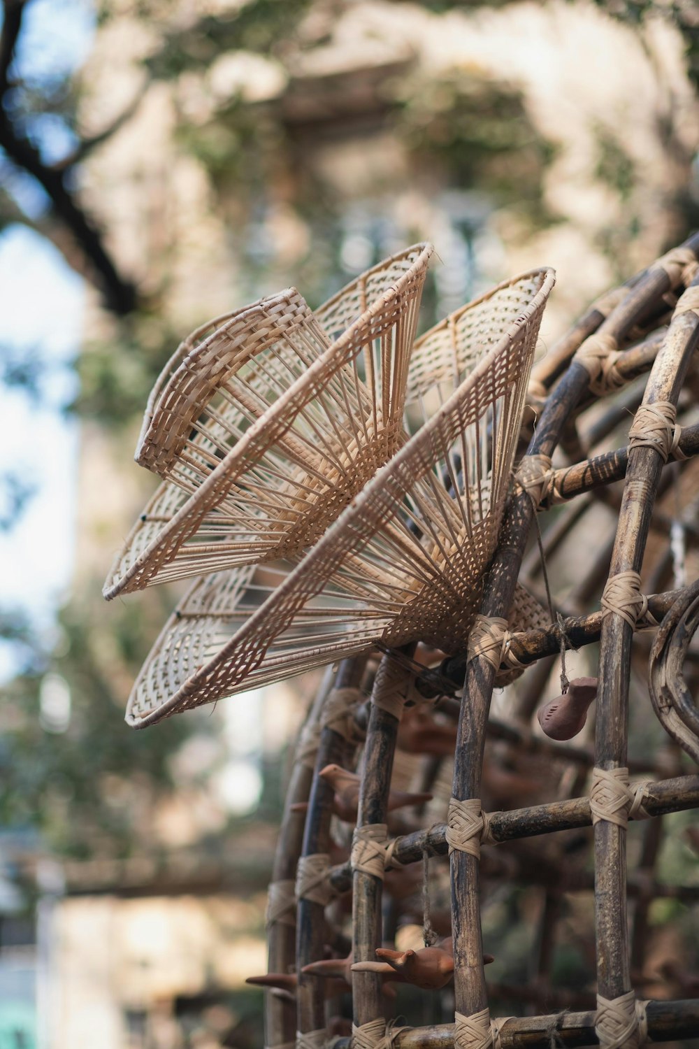 a close up of a metal fence with a tree in the background